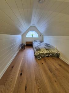 a bed in the middle of a room with a window at Toftahöjden 7 in Växjö