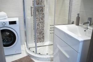 a bathroom with a washing machine and a sink at Flat with Unforgettable View in Budapest