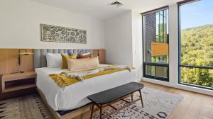 une chambre avec un grand lit et une grande fenêtre dans l'établissement Stowe Mt Resort Treehouse Ski in Ski Out Mt Views By Stowe Mountain Rentals, à Stowe
