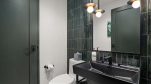 une salle de bain avec un lavabo, des toilettes et un miroir dans l'établissement Stowe Mt Resort Treehouse Ski in Ski Out Mt Views By Stowe Mountain Rentals, à Stowe 21 autres photos