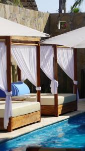 two beds in front of a swimming pool at Hotel Estrella de Mar in Zipolite