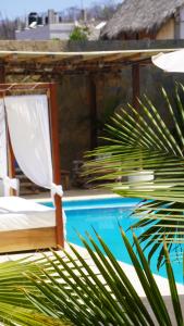 a bed and a chair next to a swimming pool at Hotel Estrella de Mar in Zipolite +58 photos