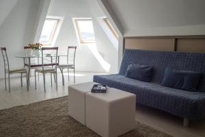 a living room with a blue couch and a table at Flat with Unforgettable View in Budapest