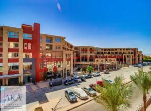 a parking lot with cars parked in front of buildings at Avenue Alhambra princess resort in Hurghada