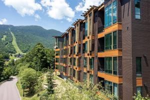 un bâtiment sur une colline à côté d'une route dans l'établissement 420 Lodge At Spruce Peak New Treehouse Unit 3 bed Sleeps 10, à Stowe