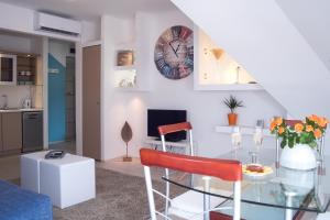 uma sala de estar com uma mesa de vidro e um relógio na parede em Flat with Unforgettable View em Budapeste