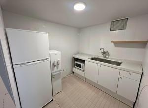 Una cocina blanca con fregadero y refrigerador. en 부일파크, en Suwon 12 fotos más