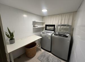 Una pequeña cocina con dos máquinas y una mesa. en 부일파크, en Suwon