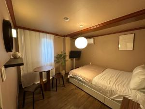 Un pequeño dormitorio con una cama y una mesa. en 부일파크, en Suwon