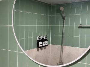 Un baño con ducha con espejo redondo. en 부일파크, en Suwon