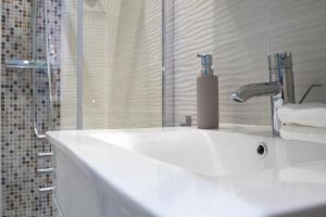 a white sink in a bathroom with a shower at Flat with Unforgettable View in Budapest