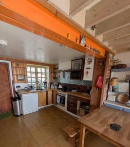 a kitchen with wooden cabinets and a table in it at Cowes View Seaside beach cottage, in Hill Head