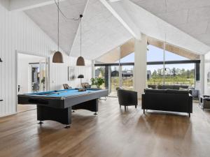 a living room with a pool table and chairs at 5 star holiday home in Idestrup in Marielyst