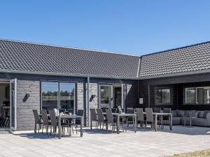 a patio with a table and chairs and a couch at 5 star holiday home in Idestrup in Marielyst