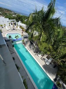 an overhead view of a swimming pool with palm trees at Kainos Tropical Boutique Hotel in Las Terrenas +55 photos