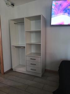 Ein weißer Schrank mit Schubladen und ein Fernseher an der Wand in der Unterkunft Corazón de viajero in Mar del Plata + 8 Fotos