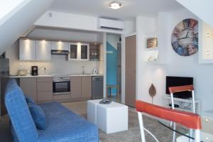 a living room with a blue couch and a kitchen at Flat with Unforgettable View in Budapest