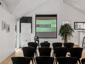 une salle de réunion avec un écran et des chaises dans l'établissement 5 star holiday home in Idestrup, à Bøtø By