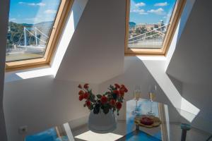 a vase with flowers on a glass table with two windows at Flat with Unforgettable View in Budapest