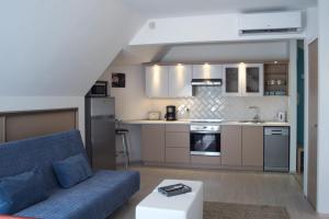 a living room with a blue couch and a kitchen at Flat with Unforgettable View in Budapest