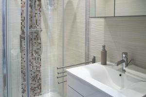 a bathroom with a sink and a glass shower at Flat with Unforgettable View in Budapest