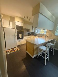 a kitchen with a refrigerator and a table and chairs at The Sunshine Haven in Delta