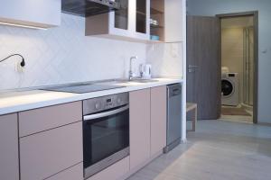 a white kitchen with a sink and a stove at Flat with Unforgettable View in Budapest