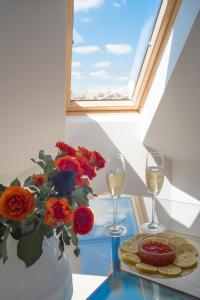 a table with two glasses of wine and a vase of roses at Flat with Unforgettable View in Budapest