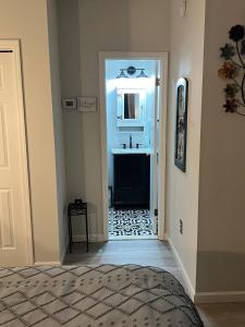 un couloir avec une salle de bain avec un lavabo et un lit dans l'établissement Cozy Studio Apartment, à Montgomery
