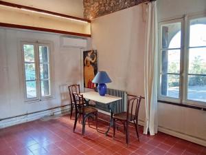a dining room with a table and chairs and windows at Le Mas Palegry Chambres d'hôtes Perpignan in Perpignan