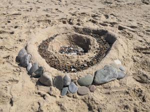 un cercle de rochers dans le sable sur une plage dans l'établissement 5 person holiday home in Harboøre, à Harboør