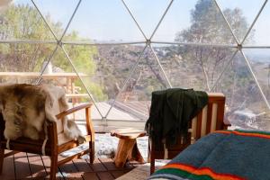 a room with a glass igloo with a dog sitting in two chairs at Cozy Dome Hideaway with Sweeping Sunrise View in Fallbrook