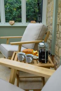 une table basse avec de la nourriture et un grille-pain dessus dans l'établissement Cragie Cottage- Beautiful Cotswold stone retreat, à Kemerton