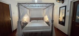 une chambre avec un lit à baldaquin avec deux lampes dans l'établissement Ruwanwali Villa, à Anurâdhapura