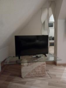 ein Wohnzimmer mit einem TV auf einem Glastisch in der Unterkunft Appartement T2 44 m2 in Kesseldorf