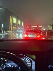 ein Auto, das im Regen eine Stadtstraße entlangfährt in der Unterkunft xto in Markham