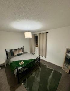 a bedroom with a bed and a window at Tartan Nest- Entire house- Sleeps 8 guests in Mansewood