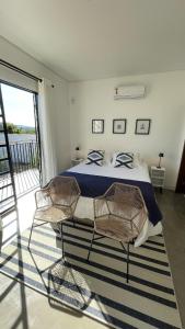 ein Schlafzimmer mit einem Bett und zwei Stühlen in der Unterkunft Casa nova ideal para familia in Cavalcante