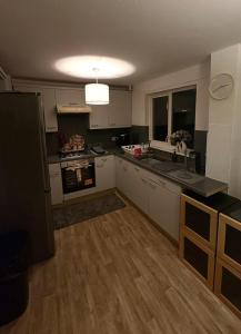 a kitchen with white cabinets and a wooden floor at Tartan Nest- Entire house- Sleeps 8 guests in Mansewood