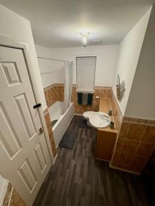 a bathroom with a tub and a toilet and a sink at Tartan Nest- Entire house- Sleeps 8 guests in Mansewood
