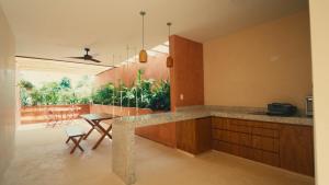 a kitchen with a counter and a table and chairs at Casa Sofía Centro in Mérida