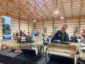 a man sitting at a table in a room with tables at Hidden Gem Farm Homestead Sleeps 12 &Fresh Produce in Spring Hill