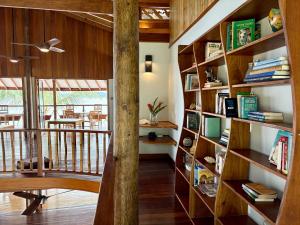 ein Raum mit Holzregalen mit Büchern in der Unterkunft Bocas Beachfront Lodge Spacious Corner King Suite Ocean View Sand Level in Bocas del Toro