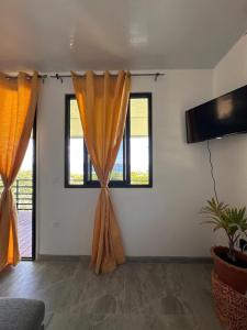 Una sala de estar con cortinas y ventanas naranjas. en Heikauiki home, en Uturoa 9 fotos más