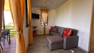 Una sala de estar con un sofá y una ventana. en Heikauiki home, en Uturoa
