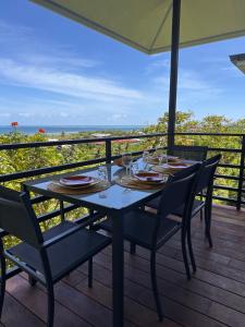 Una mesa en una terraza con vista al océano. en Heikauiki home, en Uturoa