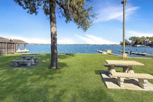 a park with picnic tables and a tree next to the water at Aspen Drive in Montgomery +40 photos