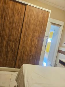 a bedroom with a wooden door and a bed at Urban Center Apartamentos in Salto del Guairá