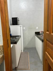 a small kitchen with a refrigerator and a counter at Studio 04 in Aracruz +3 photos