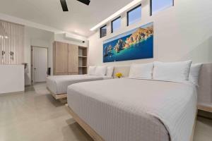 a bedroom with two beds and a painting on the wall at Double Suite Luxury Retreat 605 Tower in Cabo San Lucas